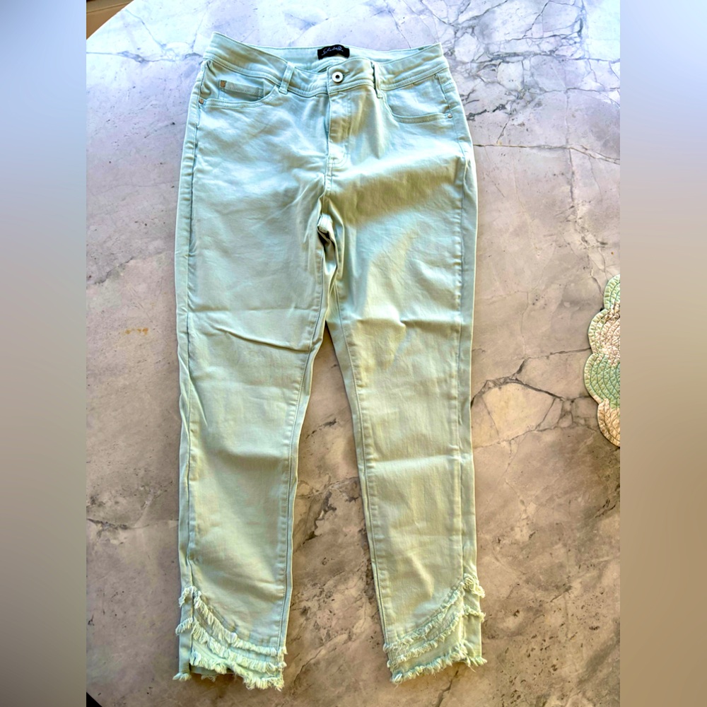 Light blue denim jeans with ruffle ankle design.